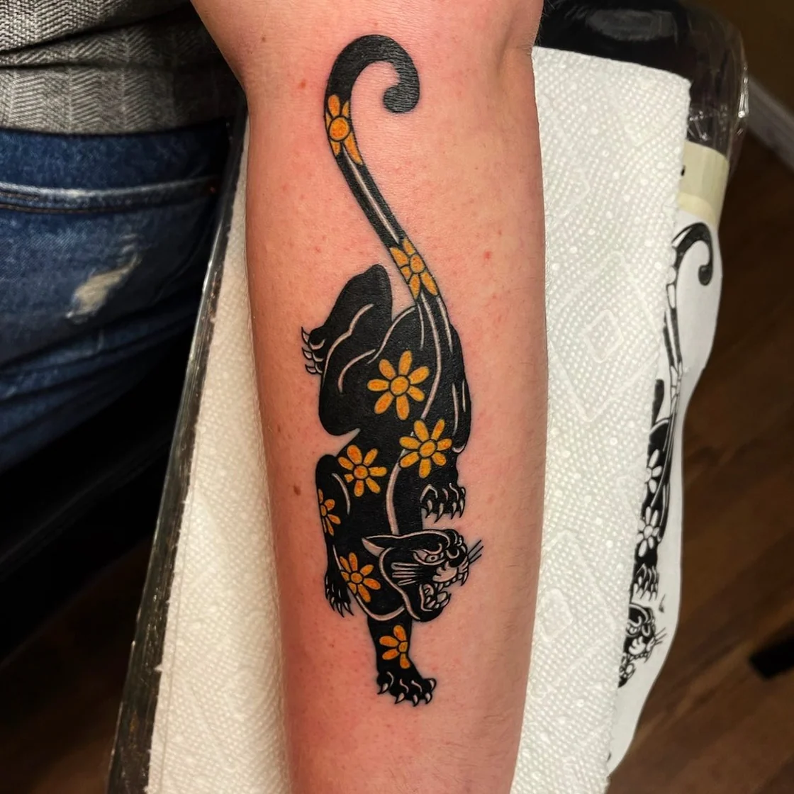 A traditional jaguar design uses bold linework, dark patterning, and compact shading in a strong animal tattoo composition. Tattoo work by Brian of Vicious Ink.